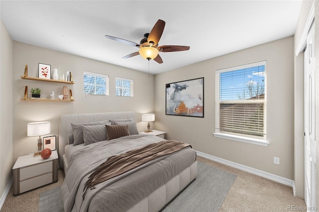 carpeted bedroom with ceiling fan and baseboards