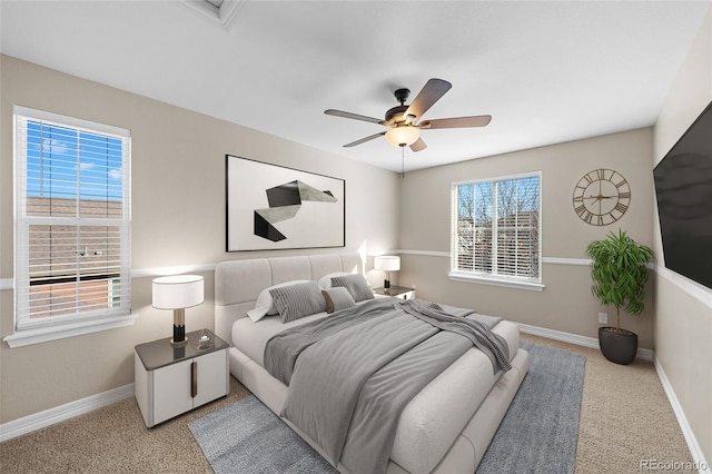 bedroom featuring baseboards, multiple windows, and light carpet