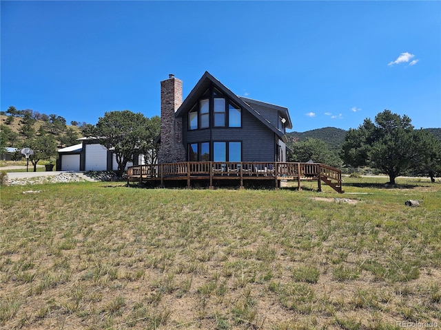 view of yard with a deck with mountain view, an outdoor structure, and a garage