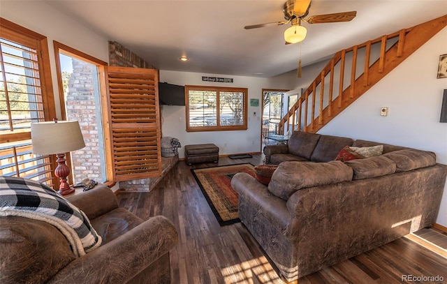 living room featuring ceiling fan, dark hardwood / wood-style floors, and brick wall