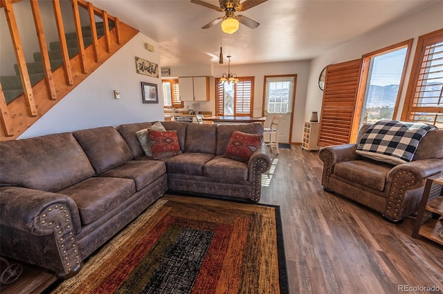 living room featuring dark wood-type flooring and ceiling fan with notable chandelier