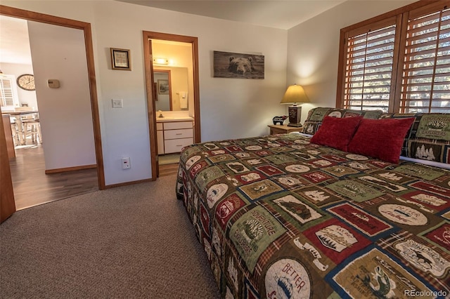 bedroom with ensuite bathroom and hardwood / wood-style flooring