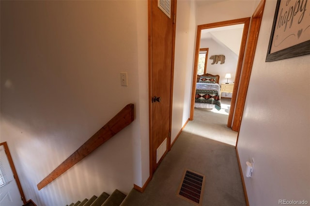 hallway with light colored carpet and vaulted ceiling