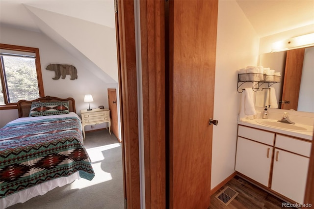 carpeted bedroom featuring vaulted ceiling and sink