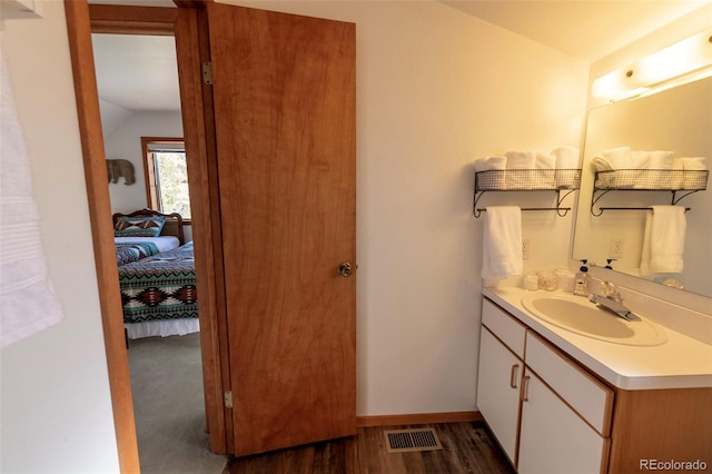 bathroom featuring lofted ceiling, hardwood / wood-style floors, and vanity