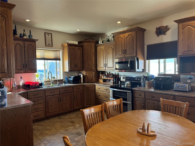 kitchen with sink, light tile patterned floors, and appliances with stainless steel finishes