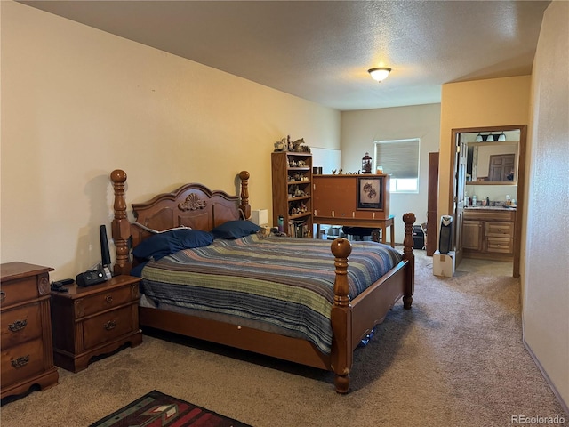 carpeted bedroom with a textured ceiling and connected bathroom