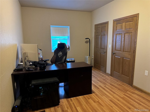 home office with light hardwood / wood-style flooring