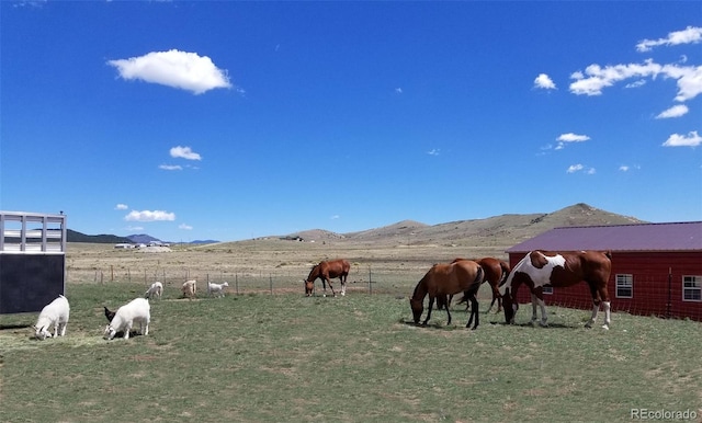 view of stable featuring a mountain view and a rural view