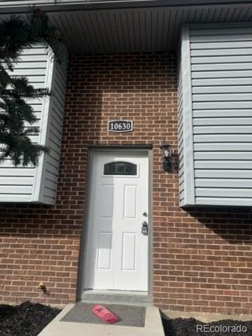 view of exterior entry with brick siding