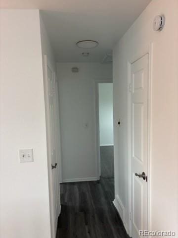 hallway with baseboards and dark wood-style flooring
