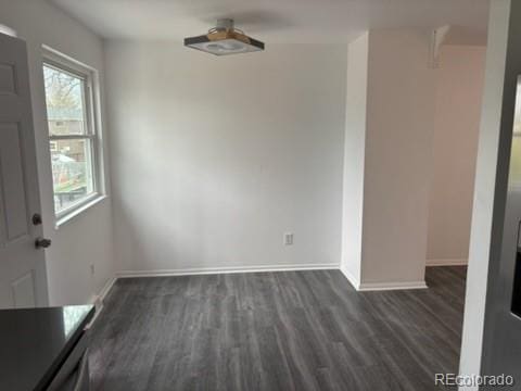 unfurnished dining area with baseboards and dark wood finished floors