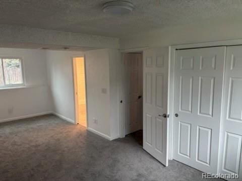 unfurnished bedroom with baseboards, carpet, and a textured ceiling