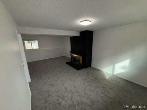 unfurnished living room with a wood stove and carpet flooring