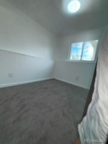unfurnished room featuring baseboards and carpet