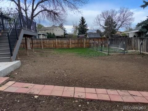 view of yard with fence and stairs