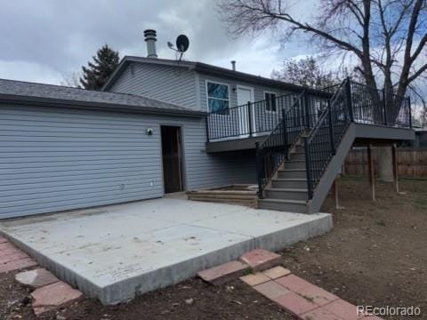 back of house with stairway, a wooden deck, and a patio area