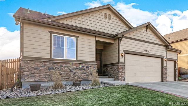 view of front facade with concrete driveway, fence, a garage, stone siding, and a front lawn