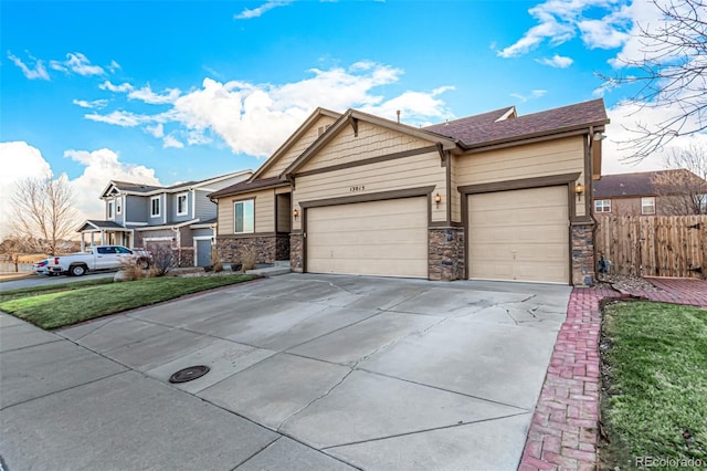 view of front of house with a garage, fence, driveway, stone siding, and a front lawn