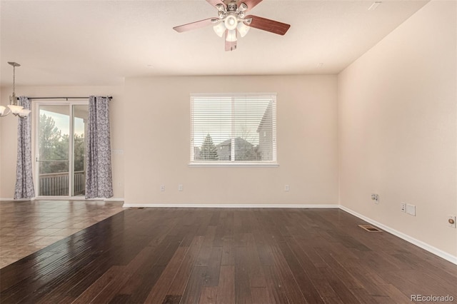 spare room featuring baseboards, visible vents, and dark wood-type flooring