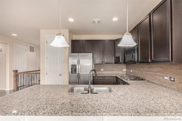 kitchen featuring stainless steel appliances, a sink, visible vents, dark brown cabinets, and decorative backsplash