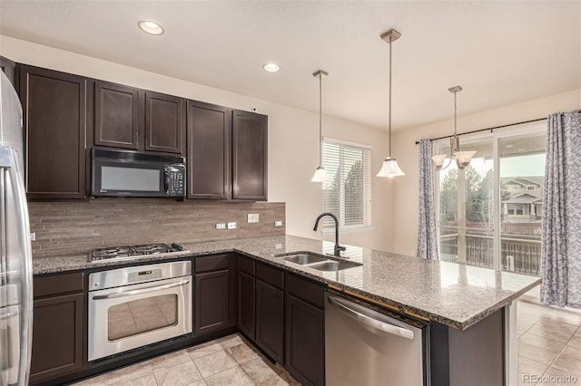 kitchen featuring dark brown cabinetry, decorative backsplash, appliances with stainless steel finishes, a peninsula, and a sink