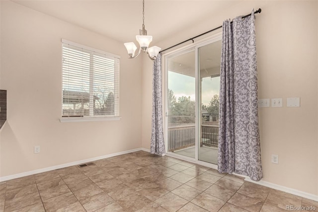 unfurnished dining area featuring baseboards, visible vents, and a notable chandelier