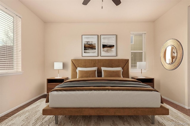 carpeted bedroom with ceiling fan and baseboards