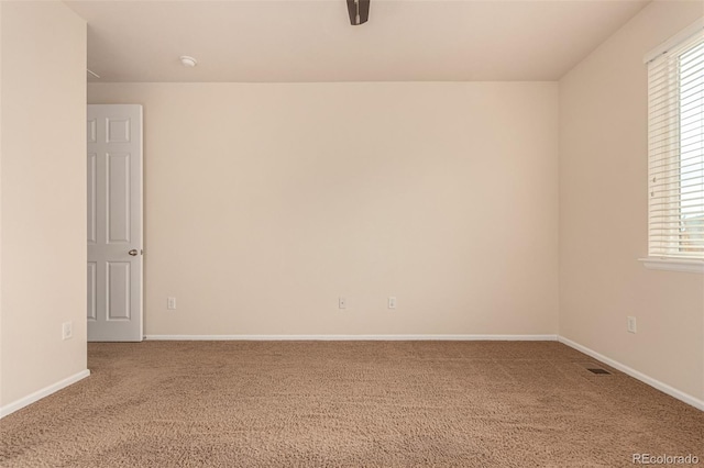 carpeted empty room featuring visible vents and baseboards