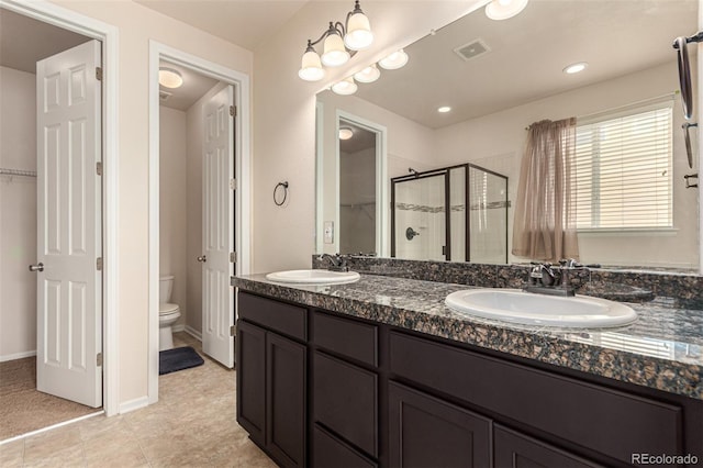 bathroom with double vanity, a stall shower, visible vents, and a sink