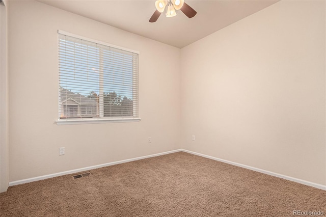 carpeted empty room with ceiling fan, visible vents, and baseboards