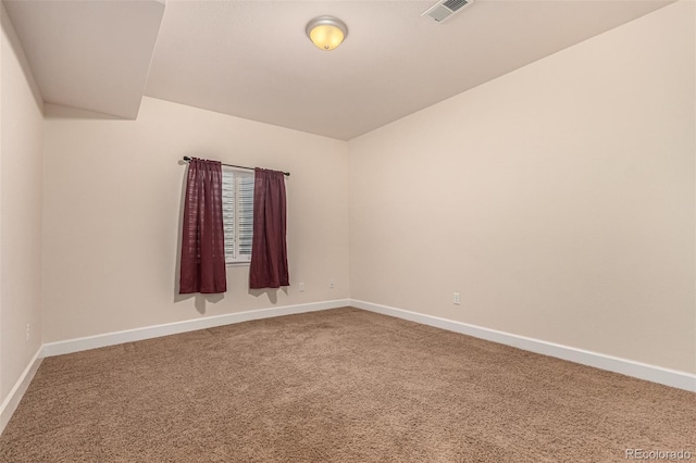 carpeted empty room with visible vents and baseboards