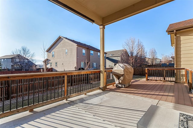 wooden deck with a residential view, a fenced backyard, and area for grilling