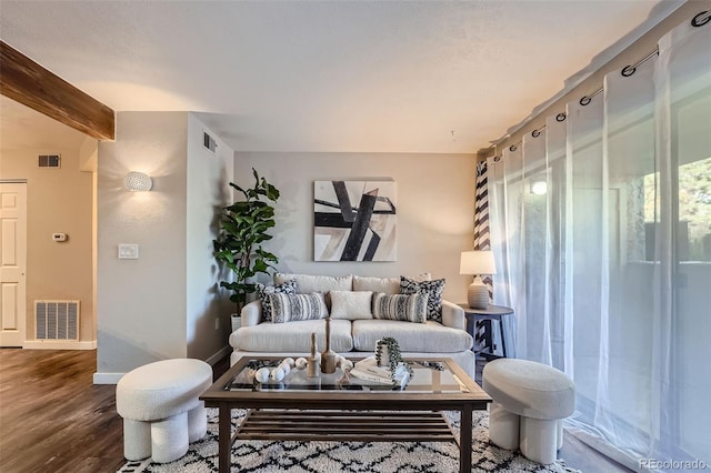 living room featuring beam ceiling and hardwood / wood-style flooring