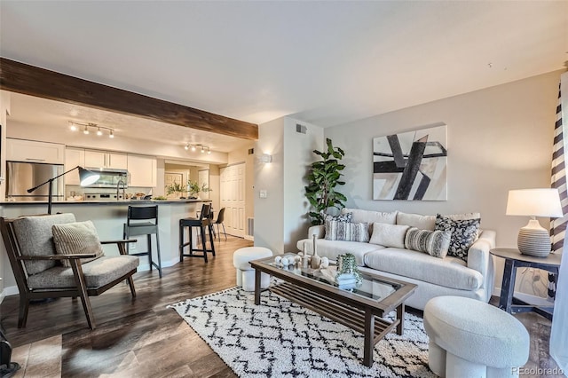 living room featuring beam ceiling, dark hardwood / wood-style floors, and rail lighting