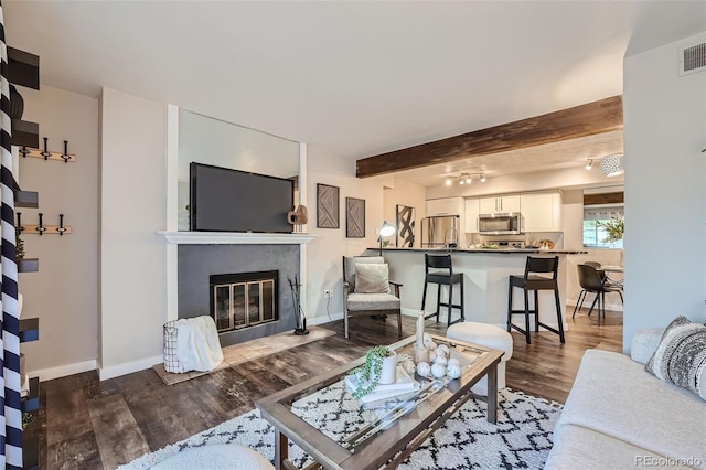 living room with beamed ceiling and dark hardwood / wood-style flooring