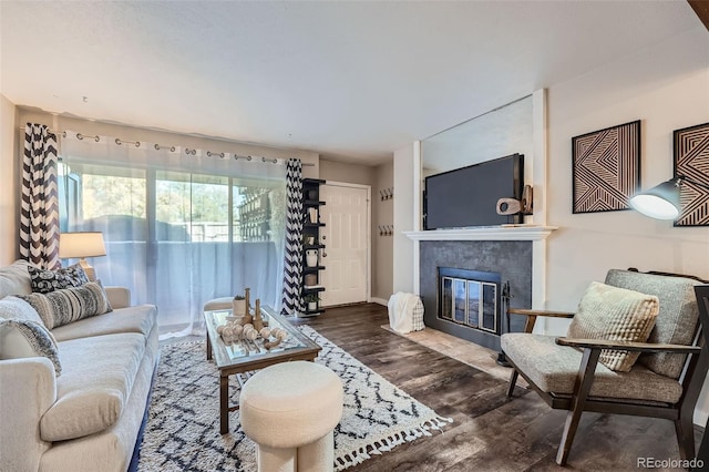 living room with dark hardwood / wood-style flooring and a tile fireplace