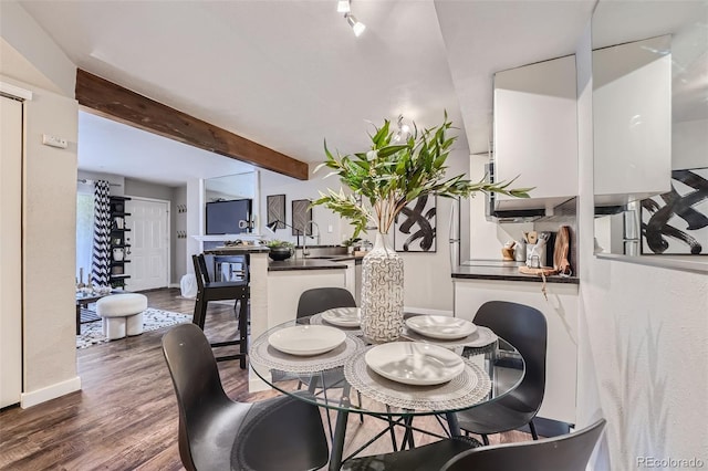 dining room with beam ceiling and dark hardwood / wood-style floors