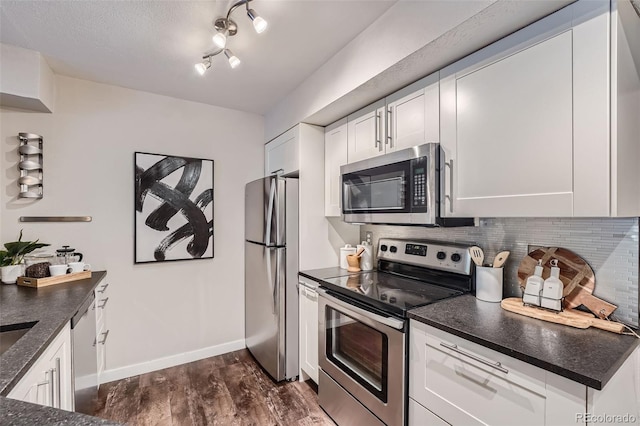 kitchen featuring appliances with stainless steel finishes, dark hardwood / wood-style floors, white cabinetry, and tasteful backsplash