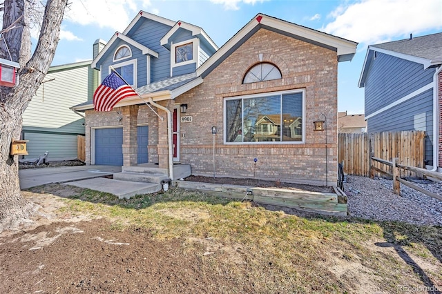 view of front of house with brick siding, a chimney, driveway, and fence