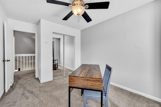 carpeted home office with a ceiling fan, baseboards, and a textured ceiling