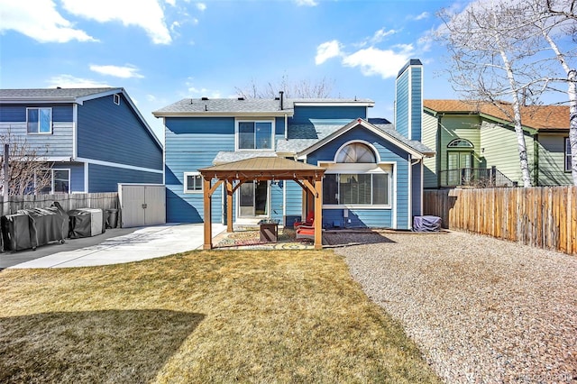 back of house featuring a lawn, a patio, a fenced backyard, a gazebo, and roof with shingles