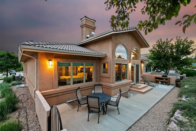 2467 Spanish Oak Ter, Colorado Springs, CO 80920 - rear view of property with a patio, stucco siding, a chimney, and a tiled roof