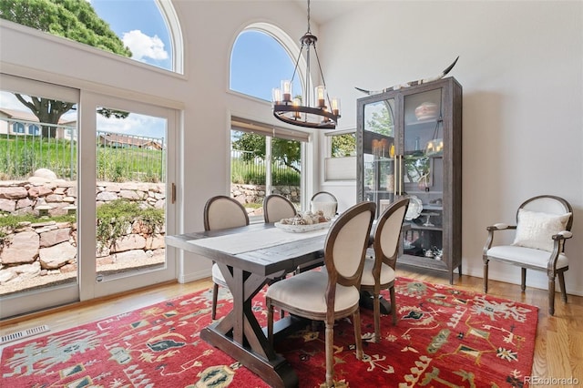 2467 Spanish Oak Ter, Colorado Springs, CO 80920 - dining space featuring a chandelier, light wood-style flooring, and a towering ceiling