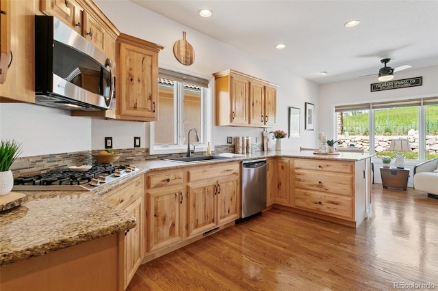 2467 Spanish Oak Ter, Colorado Springs, CO 80920 - kitchen featuring stainless steel appliances, a peninsula, light wood finished floors, light brown cabinets, and recessed lighting