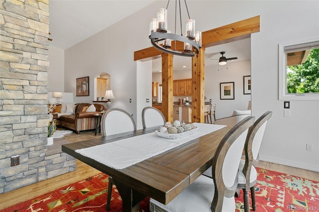 2467 Spanish Oak Ter, Colorado Springs, CO 80920 - dining space featuring light wood finished floors, a ceiling fan, a chandelier, high vaulted ceiling, and arched walkways