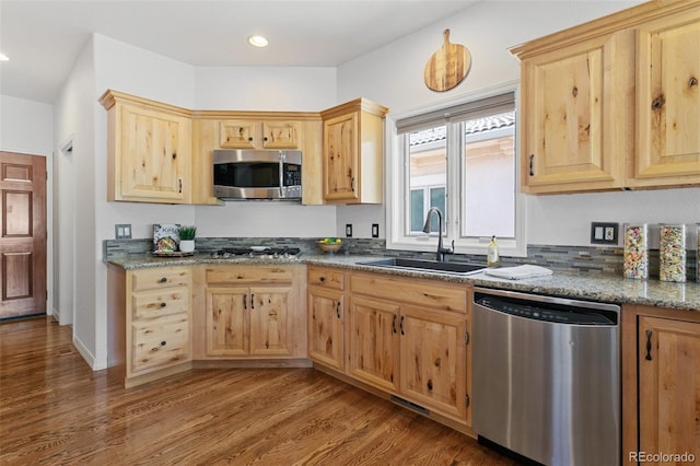 2467 Spanish Oak Ter, Colorado Springs, CO 80920 - kitchen featuring appliances with stainless steel finishes, light brown cabinets, wood finished floors, dark stone counters, and recessed lighting