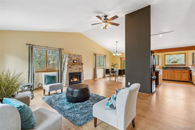 10668 Crystal Way, Morrison, CO 80465 - living area featuring a chandelier, light wood finished floors, ceiling fan, lofted ceiling, and a stone fireplace
