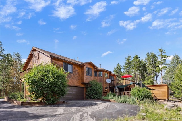 10668 Crystal Way, Morrison, CO 80465 - view of front of property with driveway, a wooden deck, and a garage