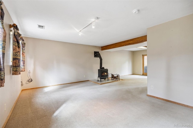 10668 Crystal Way, Morrison, CO 80465 - unfurnished living room with a wood stove, carpet flooring, rail lighting, and beamed ceiling